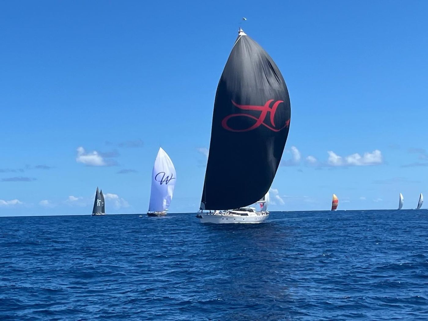 Superyachts running downwind under spinnaker in open Caribbean water at The Superyacht Challenge, an engagement in The Mansa Court season