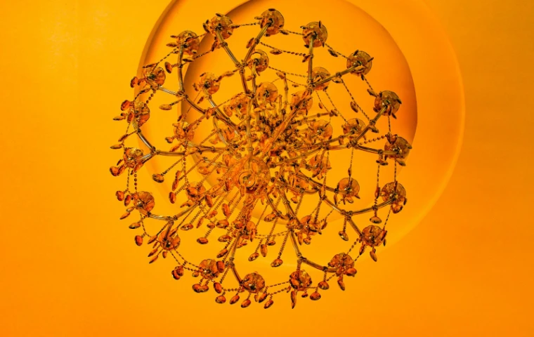 A crystal chandelier seen from below against a ceiling washed in amber light at The Vernal Ball in New York, the late-April ball held by The Mansa Court