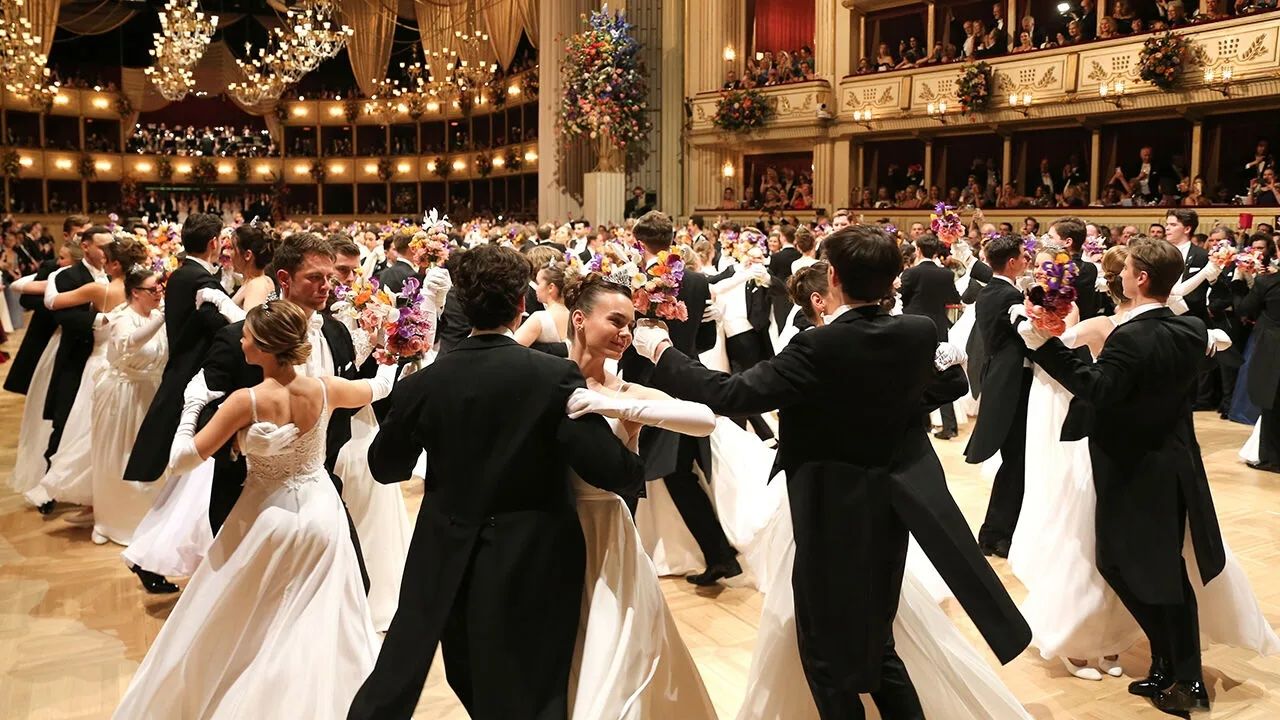 Couples waltzing under the chandeliers late in the evening