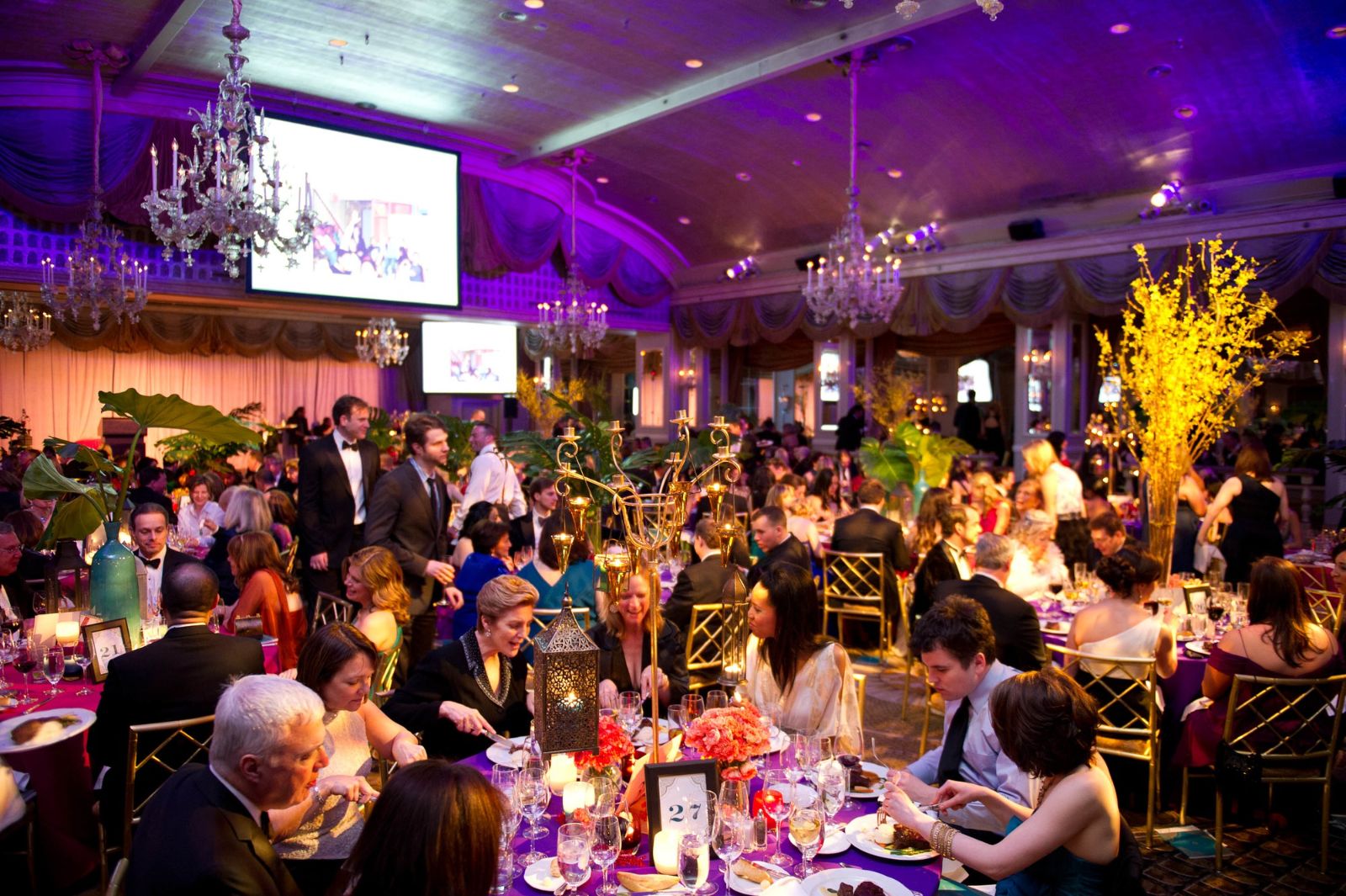 Dinner served across a chandeliered ballroom in candlelight at The Winter Ball, New York