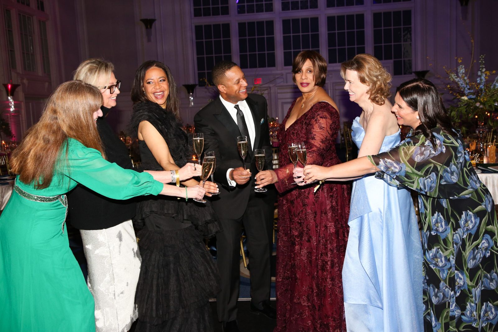 Guests in evening dress raising a champagne toast in the ballroom at The Winter Ball, New York