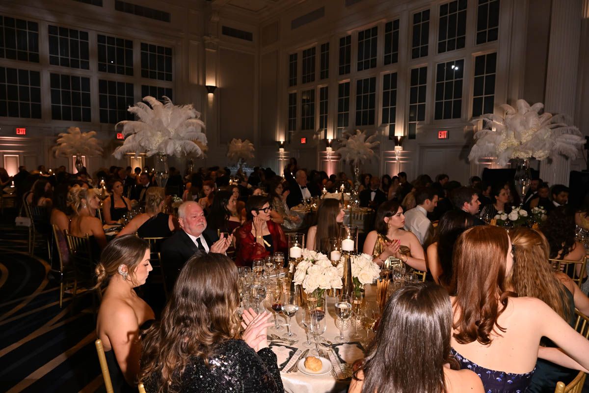 Guests at dinner under tall ostrich-plume centrepieces at The Winter Ball, New York