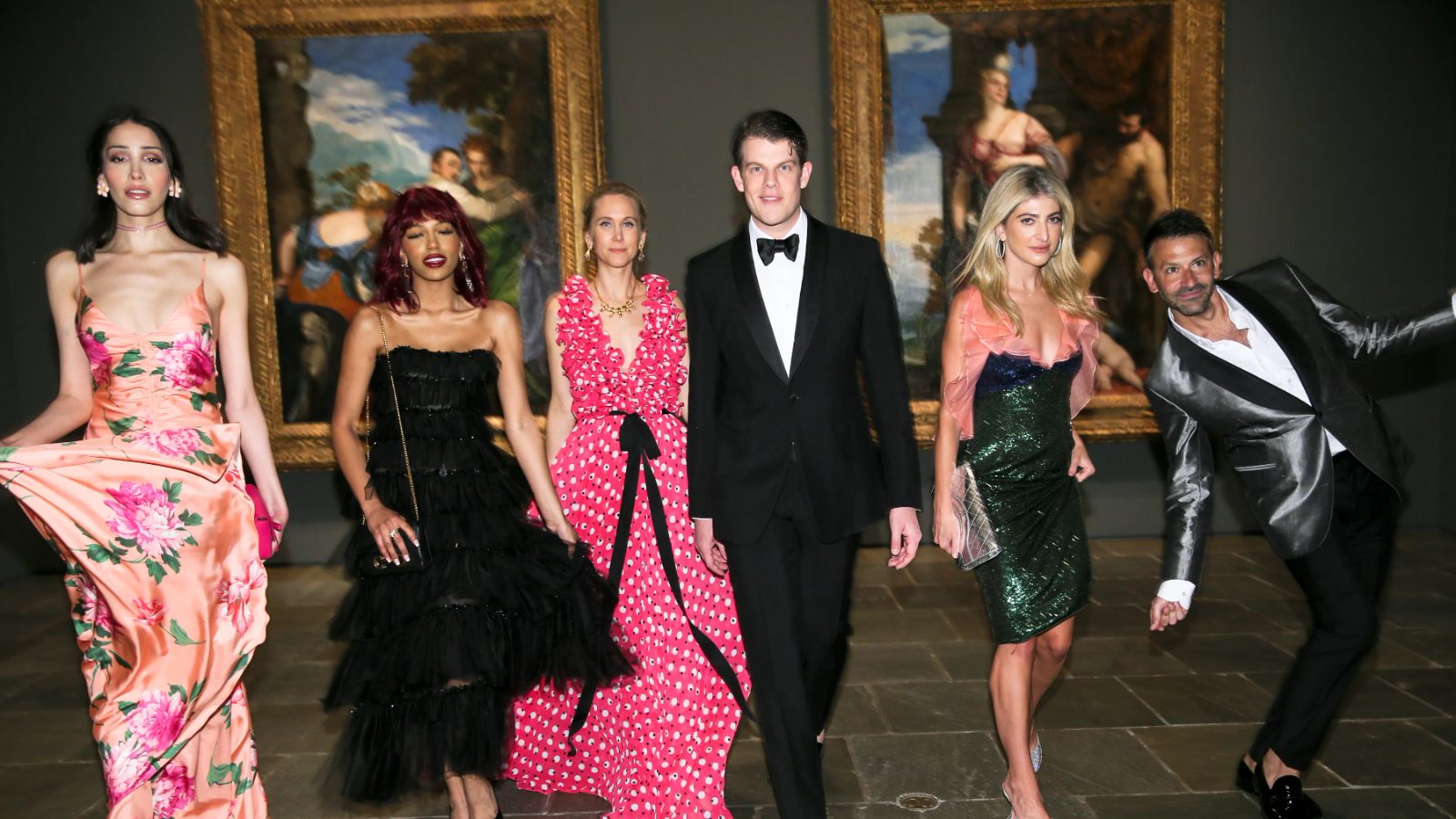 Guests in evening gowns and black tie walking the Titian gallery at The Young Fellows Ball, The Frick Collection, attended by members of The Mansa Court