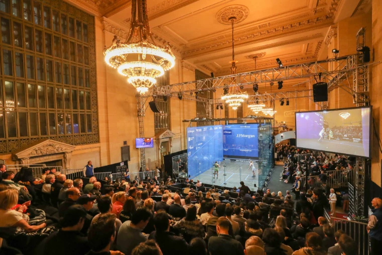 The glass court lit under Vanderbilt Hall’s chandeliers, the stands full. Tournament of Champions, Vanderbilt Hall, Grand Central Terminal, New York, in the season calendar of The Mansa Court