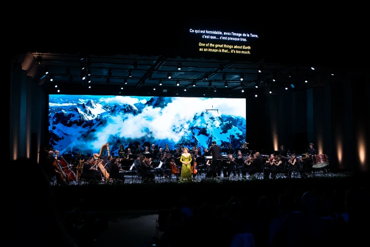 Renée Fleming sings with the Verbier Festival Chamber Orchestra in the Salle des Combins, a mountain film on the screen behind (2026).
