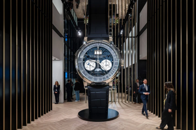 A giant A. Lange & Söhne Datograph Perpetual Tourbillon standing between the slatted walls of the Lange stand at Watches and Wonders Geneva, a mid-April engagement in the season calendar of The Mansa Court