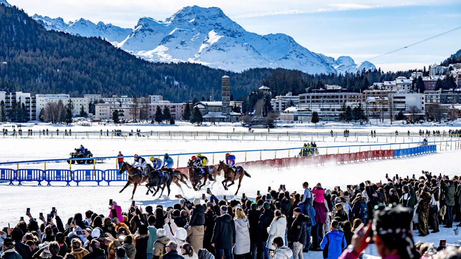 Spectators lining the frozen-lake racecourse at White Turf with St. Moritz and the Engadine peaks behind